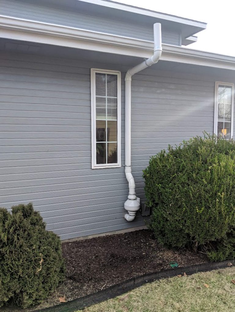 Radon system repair on mitigation fan on house exterior
