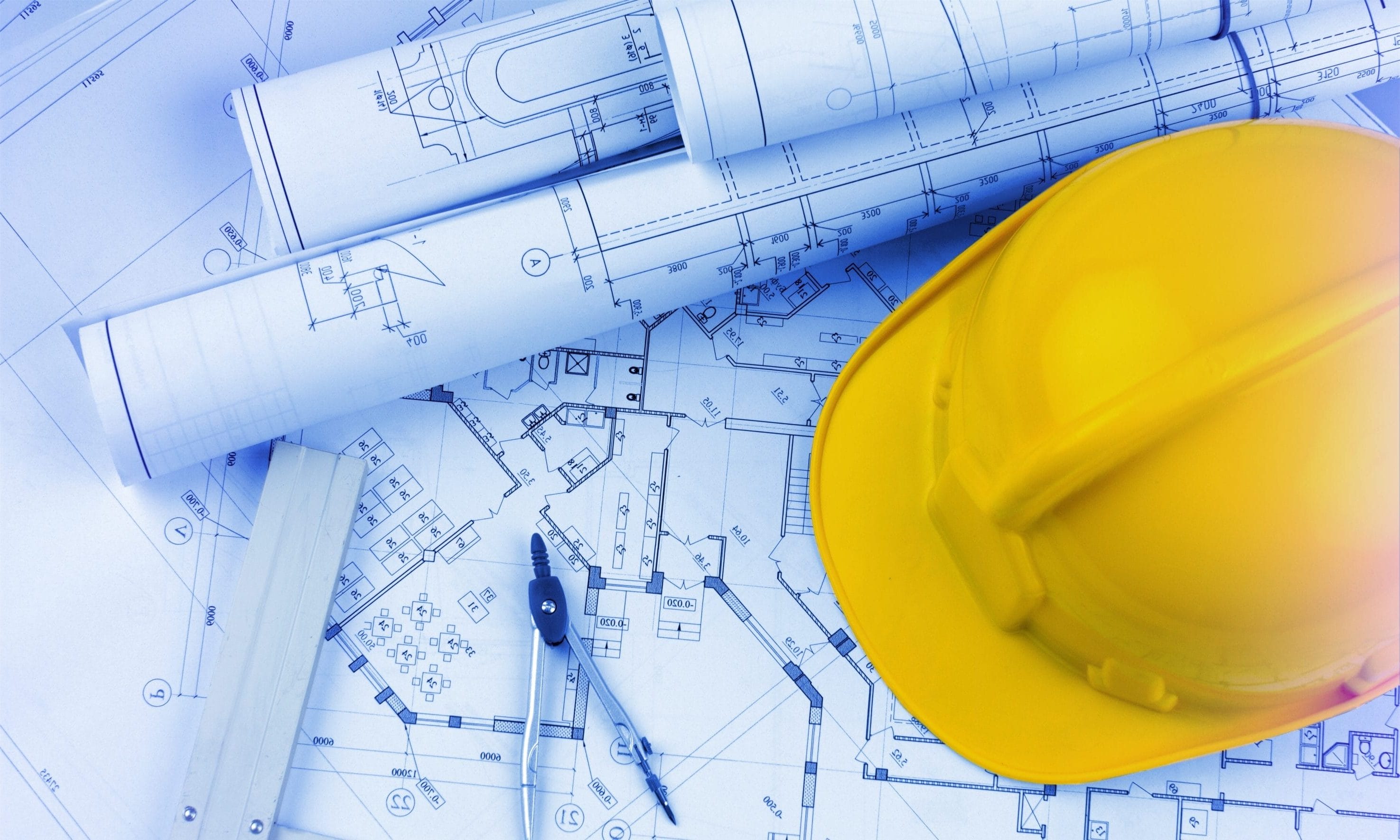 Blueprints and Yellow Hard Hat for Radon Mitigation Planning

