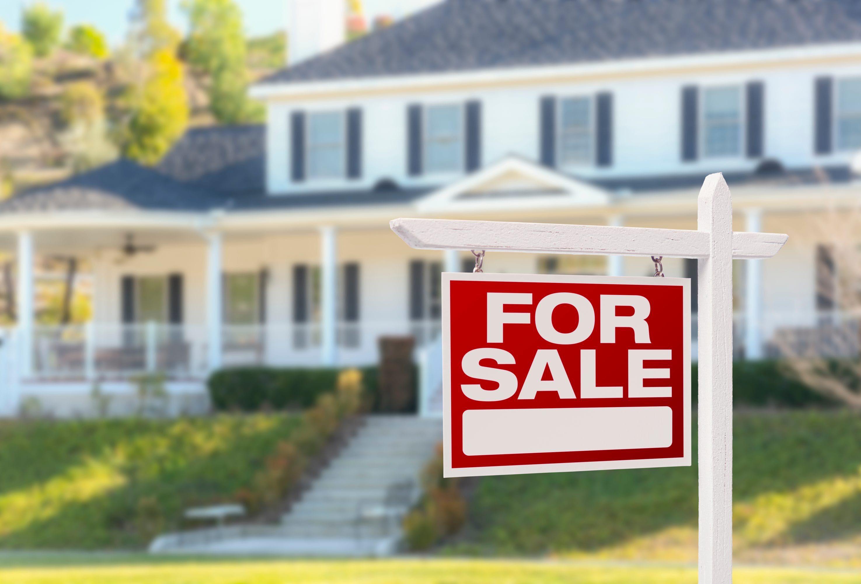 House for Sale Sign in Front of Home Indicating Radon Mitigation Potential
